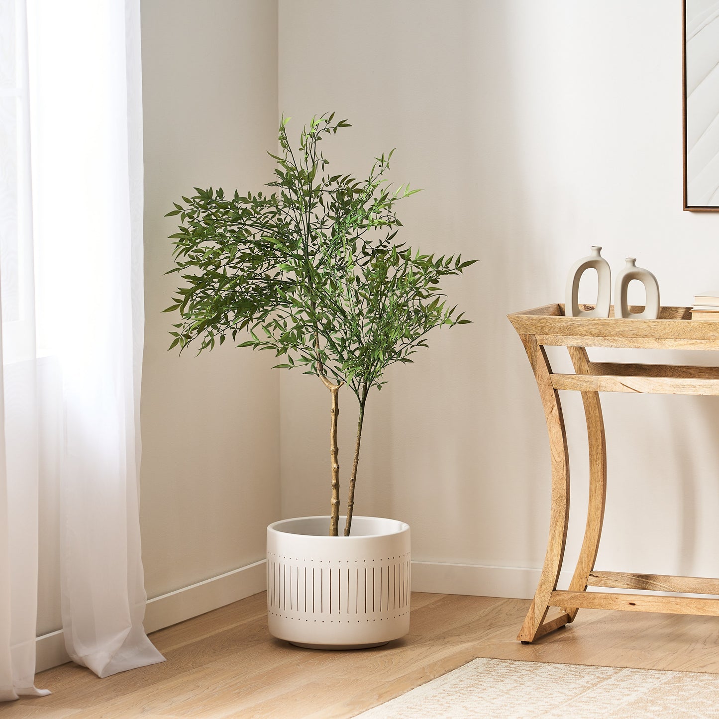 120CM ARTIFICIAL NANDINA in a white perforated planter indoors beside a wooden console table.